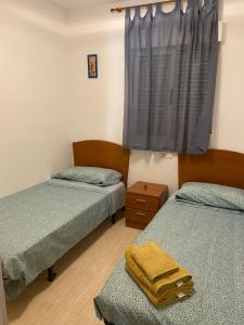 zwei Einzelbetten in einem Zimmer mit Fenster in der Unterkunft VISTA MAR I - Magic World in El Borseral