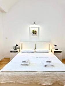 蒂米什瓦拉Le Mignion的卧室里有一张白色的大床和两个床头柜