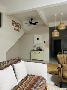 a living room with a couch and a ceiling fan at Ruma Shinkou in Kota Tinggi