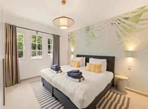 a bedroom with a large bed with towels on it at Luz Abondante in Jan Thiel +16 photos