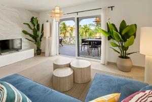 a living room with a blue couch and two stools at Luz Abondante in Jan Thiel