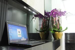 a laptop computer sitting on top of a counter with flowers at Homy Central in Hong Kong