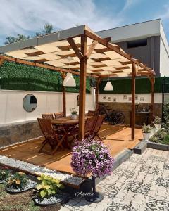 eine hölzerne Pergola mit Tisch und Stühlen auf einer Terrasse in der Unterkunft Ayshira Aparts in Kemer