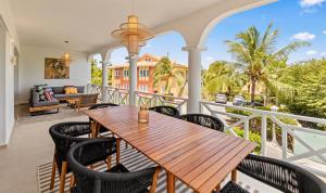 a balcony with a wooden table and chairs at Luz Abondante in Jan Thiel