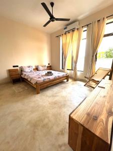 a bedroom with a bed and a ceiling fan at Alcyone Residence - Ocean View Villa in Muyuni