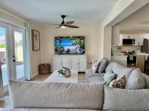 a living room with a couch and a ceiling fan at Brand New Pool! Waterfront Canal Luxury Home in Apollo Beach