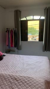a bedroom with a large bed and a window at Casa aconchego em Angra in Angra dos Reis +8 photos