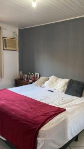 a bedroom with a large bed with a red blanket on it at Casa aconchego em Angra in Angra dos Reis
