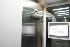 a metal elevator with a screen in a room at Homy Central in Hong Kong