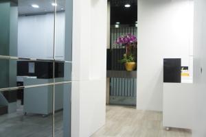 an office with glass partitioning and purple flowers at Homy Central in Hong Kong