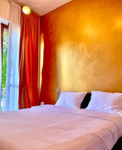 a bedroom with a bed and a red wall at Il nido di Sonia - Wi-Fi, aria condizionata e free park in Asti