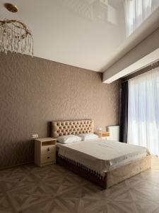 a bedroom with a large bed and a chandelier at Shato Mash in Tbilisi City