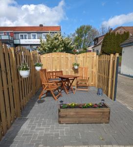 a patio with a table and chairs and a fence at Ankerplatz35 in Carolinensiel