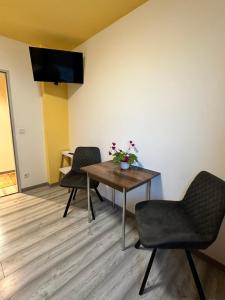 a room with a table and chairs and a television at Hostel Pinneberg in Pinneberg