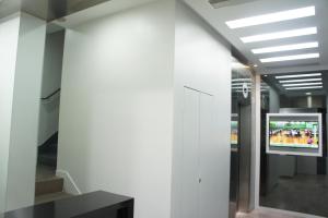 a tv on a wall in a building with a hallway at Homy Central in Hong Kong