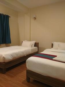 two beds sitting next to each other in a room at Hotel the valley view in Muktināth
