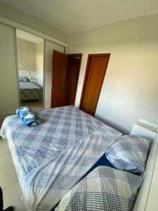 a bedroom with a bed with blue pillows on it at Lucas House in Brasilia