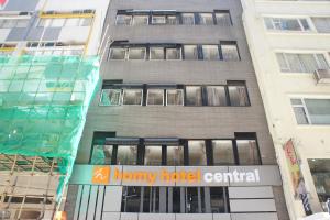 a tall building with a honey hotel central sign on it at Homy Central in Hong Kong