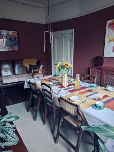 a dining room with a table with chairs and a couch at Merchant House in Bootle