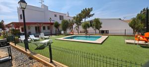 een achtertuin met een hek en een zwembad bij Finca los Barrancos in Lepe