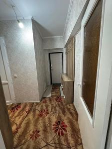 un pasillo vacío con una alfombra en el suelo en Квартира, en Karakol