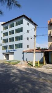 a white building with a pole in front of it at Vista Oceanica Pousada in Marataizes