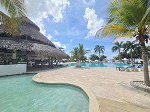 a resort with a swimming pool and palm trees at Beach Apartment At Nikki Residences 2 Bedroom in El Chirú