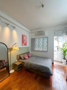 une chambre avec un lit avec des oreillers roses dessus dans l'établissement Saigon Downtown Home - 100m to Nguyen Hue Walking Street, à Hô-Chi-Minh-Ville