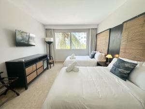 リオ・アトにあるBeach Apartment At Nikki Residences 2 Bedroomのベッド2台と机があるホテルの部屋 +29枚の写真
