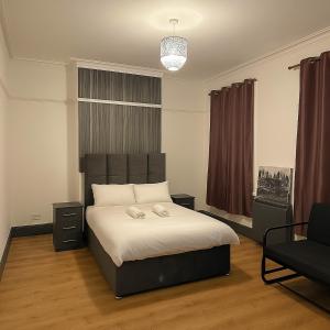 ロンドンにあるBethnal Green Nestの大きなベッドと椅子のある寝室