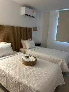 a hotel room with two beds and a basket on the bed at Vicmag house barranquilla in Barranquilla