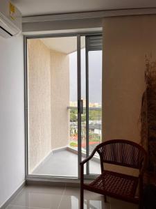 a chair sitting in front of a large window at Vicmag House Barranquilla in Barranquilla
