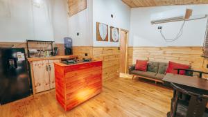a kitchen with a refrigerator and a couch in a room at Aldea Molco Avellano in Villarrica +4 photos
