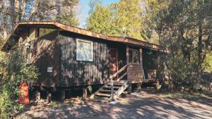 a cabin in the woods with a porch and stairs at Aldea Molco Avellano in Villarrica