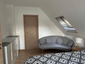 a bedroom with a couch in the corner of a room at L'échapée belle in Beinheim