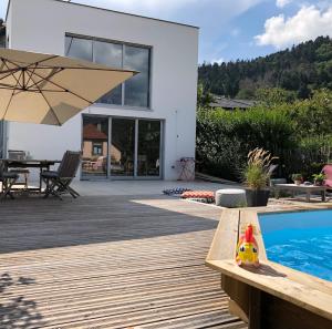 a house with a swimming pool and an umbrella at Vivez l'Alsace! Piscine, Montagne&Noël Magique in Thann