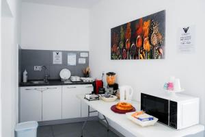 a kitchen with a white counter with a microwave at B&B Carlo V in Crotone