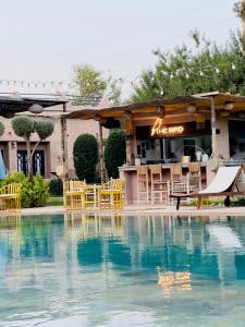 a pool with chairs and a bar in the background at The BIRD in Marrakech