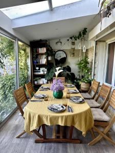 a dining room table with a yellow table cloth on it at House with garden 30 minutes to Disneyland and center of Paris in Montreuil
