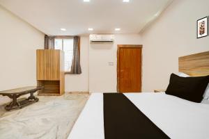 a bedroom with a bed and a desk in it at Hotel O P2 in Bhopal +21 photos