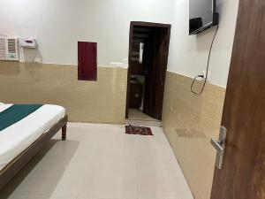 a bedroom with a bed and a door to a bathroom at Guest house in Vrindāvan