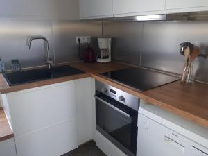 una cocina con fregadero y estufa horno superior en Ty Ar Goël, en Camaret-sur-Mer