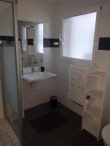 baño blanco con lavabo y ventana en Ty Ar Goël, en Camaret-sur-Mer