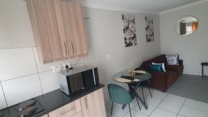 a kitchen with a small table and a microwave at Sandalion Cottage near OR Tambo Airport & Greenstone in Edenvale