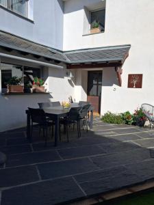 a patio with a table and chairs in front of a building at La Maison Carolane in Latour-de-Carol