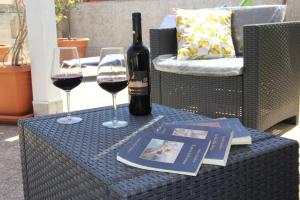 a table with a bottle of wine and two glasses at B&B Albergo Sicilia City Center in Avola