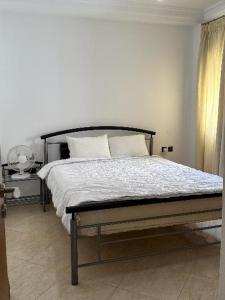 a bed with white sheets and pillows in a bedroom at دوبليكس ميرامار مرتيل in Martil