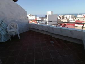 a balcony with a chair and a view of the city at دوبليكس ميرامار مرتيل in Martil