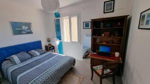 une chambre avec un lit et une table avec un ordinateur portable dans l'établissement Charmante maison en Provence, à La Crau