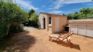 une chaise assise sur une terrasse en face d'une maison dans l'établissement Charmante maison en Provence, à La Crau